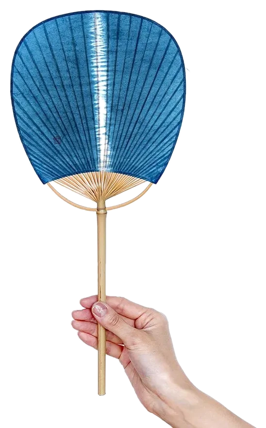 藍染の板締め絞り団扇を手に持つようす